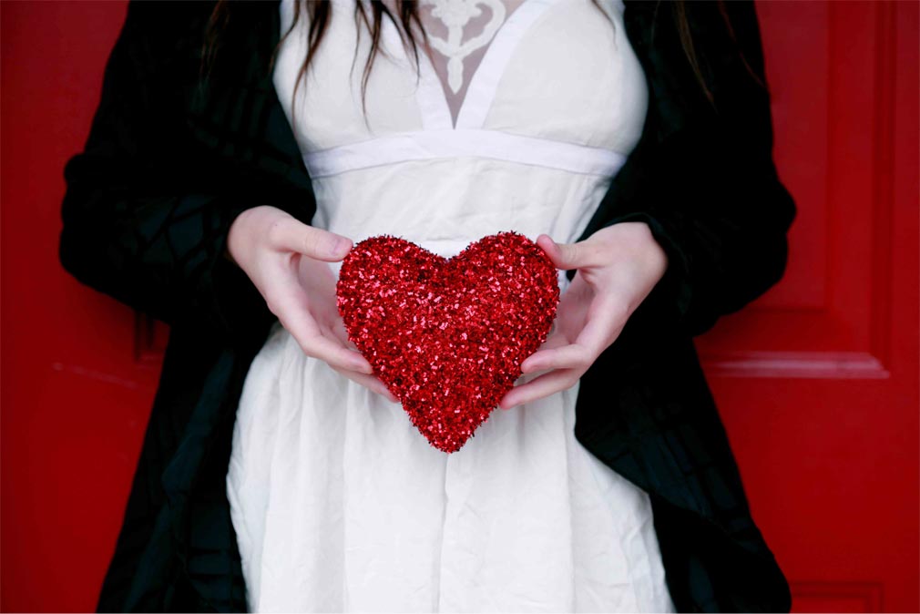 Woman holding a red pillow heart symbolizing Ukraine love.