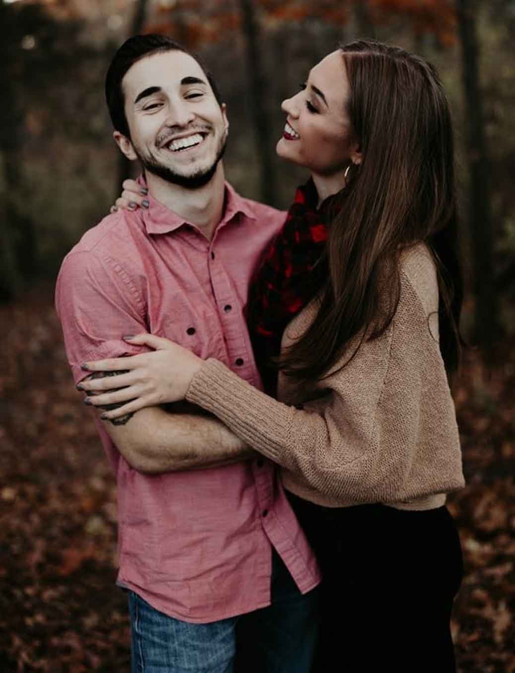 couple smiling and hugging in the forest