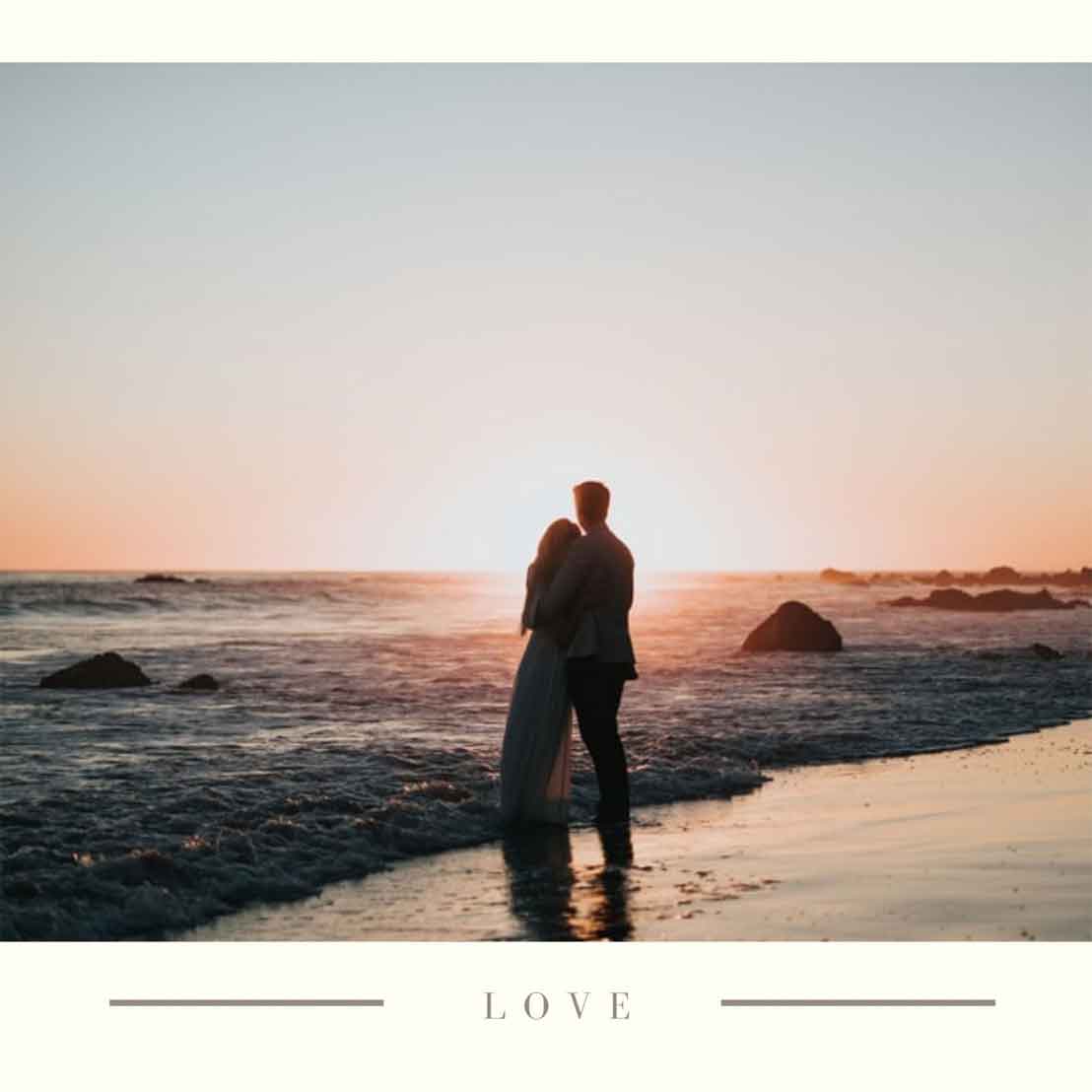 a couple standing beside each other by the beach.